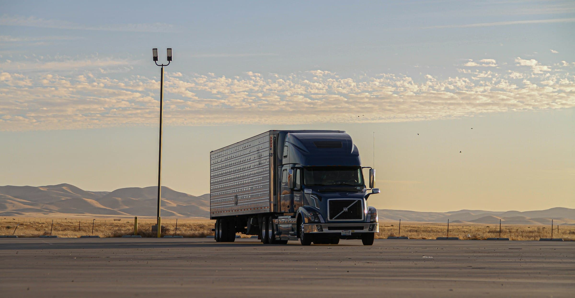 Semi-truck at golden hour with hills behind